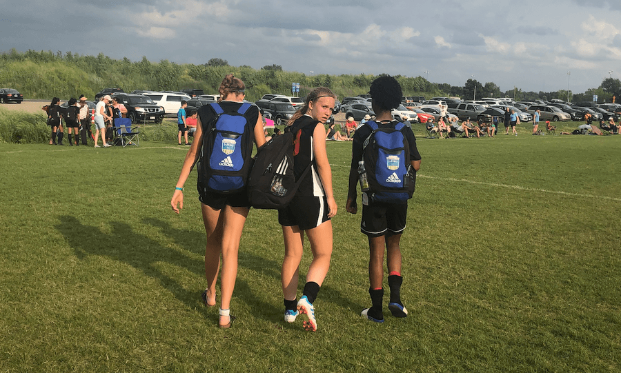Three teammates walk off the field together after a game